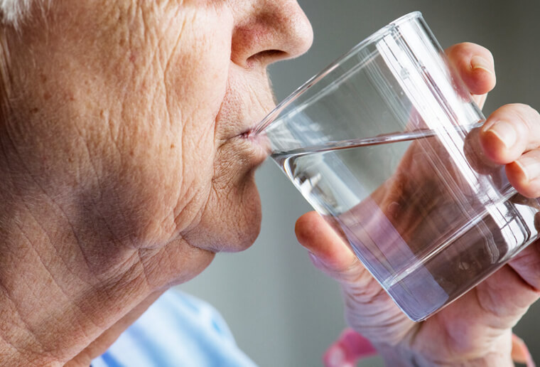 Ældre mand drikker et glas vand